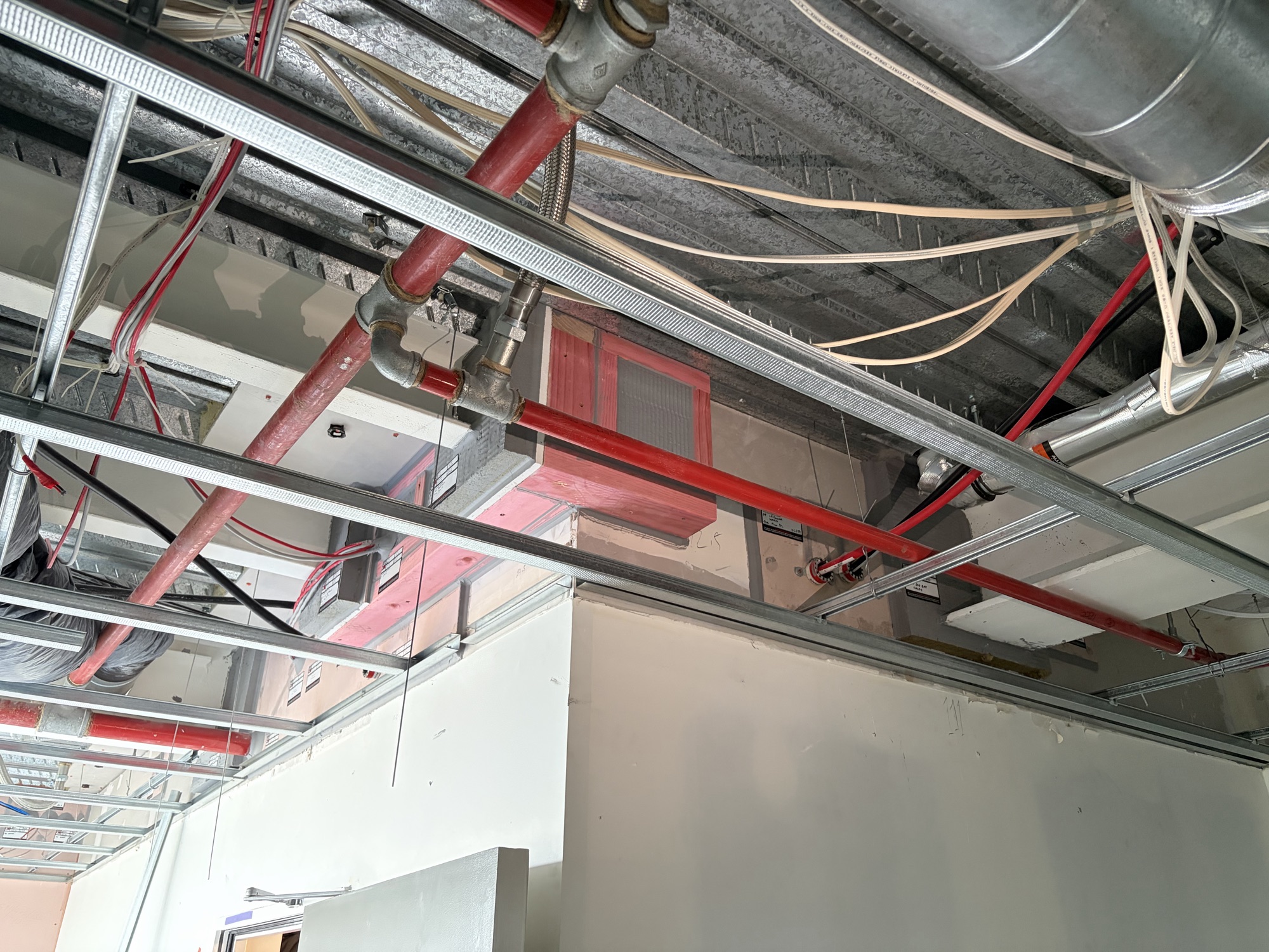 Ceiling void opened up — services, fire collars and separations identified before remediation